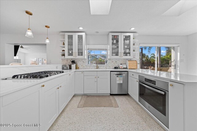 216 Cynthia Ln, Indian Harbour Beach, FL 32937 - kitchen with tasteful backsplash, a healthy amount of sunlight, a peninsula, and stainless steel appliances