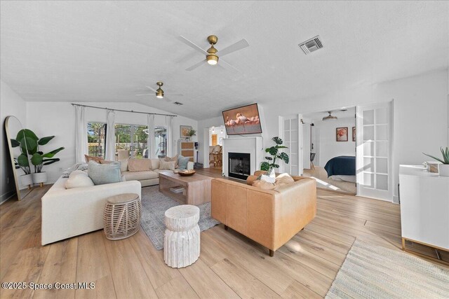 216 Cynthia Ln, Indian Harbour Beach, FL 32937 - living room with light wood-type flooring, ceiling fan, a glass covered fireplace, and visible vents