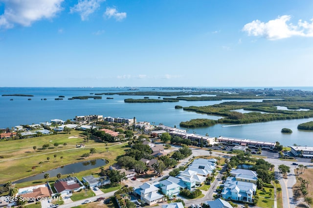 aerial perspective of suburban area featuring a nearby body of water and a golf course