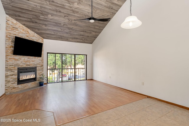 3021 Kirkland Rd NE, Palm Bay, FL 32905 - unfurnished living room featuring baseboards, ceiling fan, a stone fireplace, and high vaulted ceiling