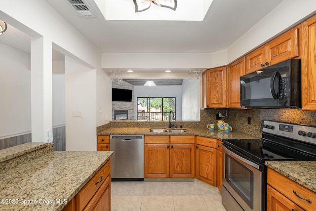 3021 Kirkland Rd NE, Palm Bay, FL 32905 - kitchen with brown cabinetry, a sink, a skylight, and stainless steel appliances