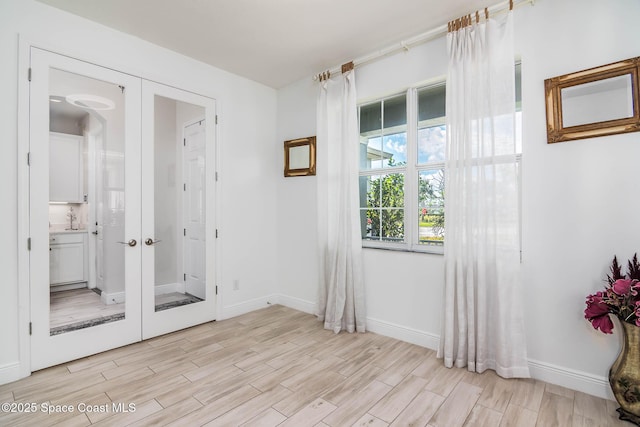 7921 Mocan Ct, Melbourne, FL 32940 - unfurnished room with light wood-style flooring, french doors, and baseboards