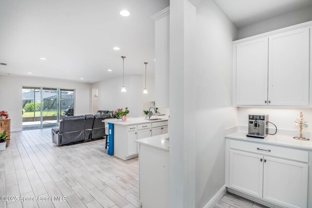 7921 Mocan Ct, Melbourne, FL 32940 - kitchen with a sink, white cabinets, light countertops, open floor plan, and recessed lighting