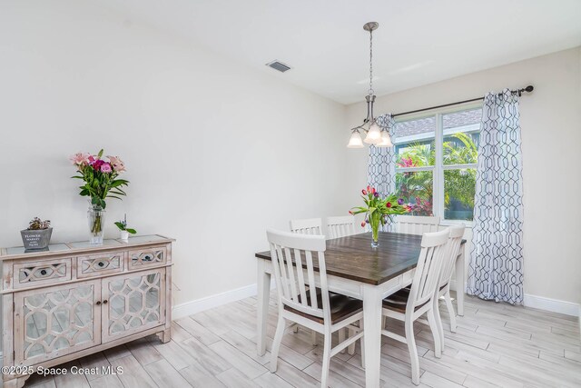 7921 Mocan Ct, Melbourne, FL 32940 - dining space featuring baseboards, wood finish floors, and a chandelier