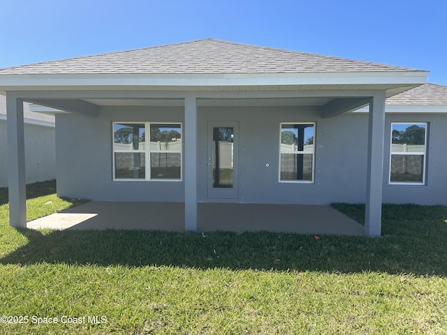 1125 Kylar Dr NW, Palm Bay, FL 32907 - back of house with a lawn, a patio area, stucco siding, and a shingled roof