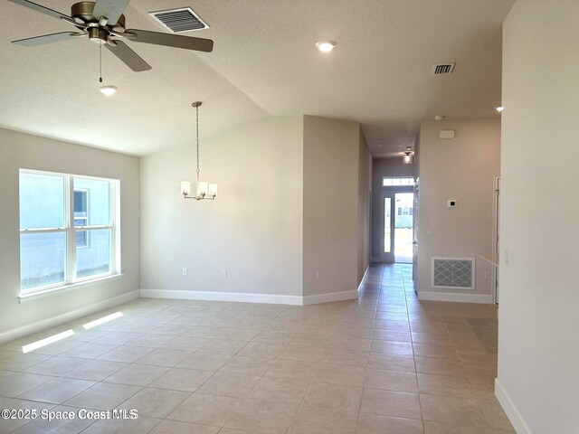 1125 Kylar Dr NW, Palm Bay, FL 32907 - spare room featuring a ceiling fan, a chandelier, vaulted ceiling, light tile patterned flooring, and baseboards