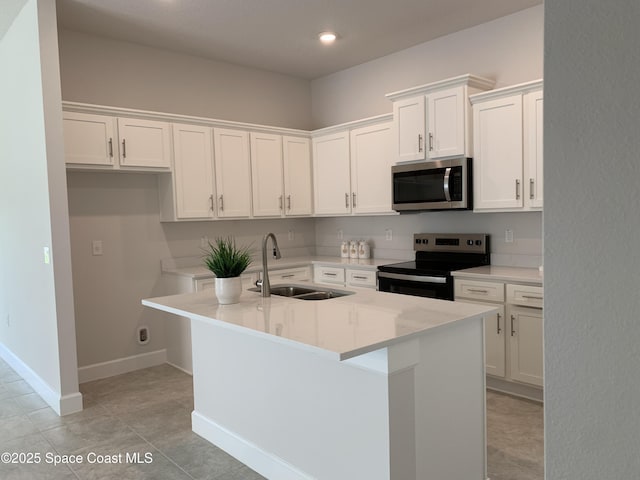 1005 Kylar Dr NW, Palm Bay, FL 32907 - kitchen with appliances with stainless steel finishes, a sink, baseboards, white cabinets, and an island with sink