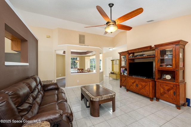 living room with lofted ceiling, a ceiling fan, visible vents, and light tile patterned floors
