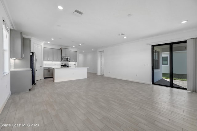 unfurnished living room featuring crown molding, light wood-type flooring, baseboards, visible vents, and recessed lighting
