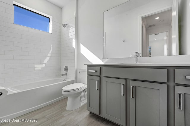 full bath with wood finished floors, toilet, vanity, and washtub / shower combination