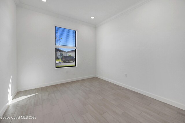 empty room with recessed lighting, baseboards, ornamental molding, and light wood-type flooring
