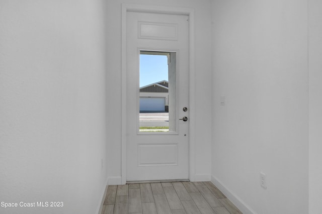 entryway with baseboards and light wood-style flooring