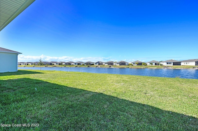 view of yard with a residential view and a water view