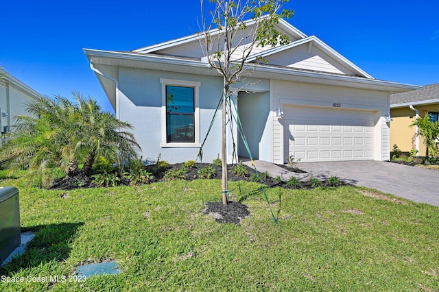 ranch-style home featuring an attached garage, driveway, a front lawn, and stucco siding