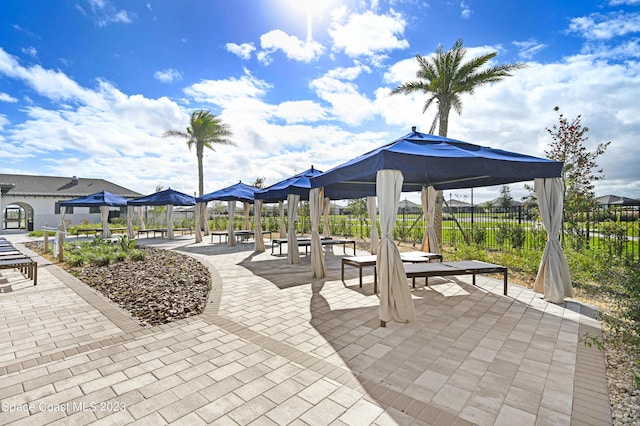 view of property's community featuring a gazebo, a patio, and fence