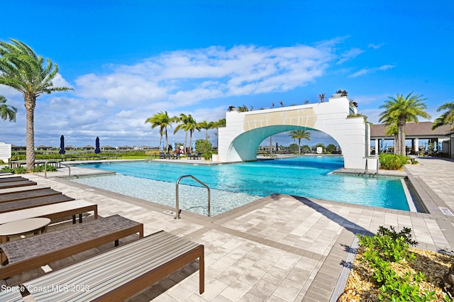 community pool with a patio area and a water slide