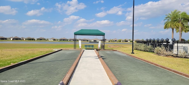 view of community with fence, a yard, a residential view, a water view, and a gazebo