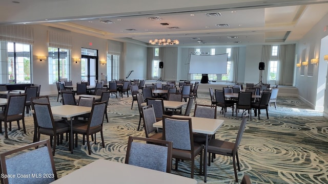 dining space featuring a raised ceiling, visible vents, and carpet flooring