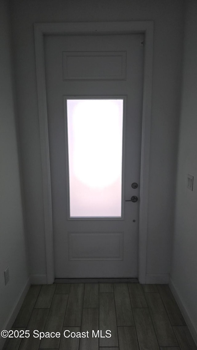 9223 Alister Dr, Melbourne, FL 32940 - doorway featuring wood tiled floor and baseboards