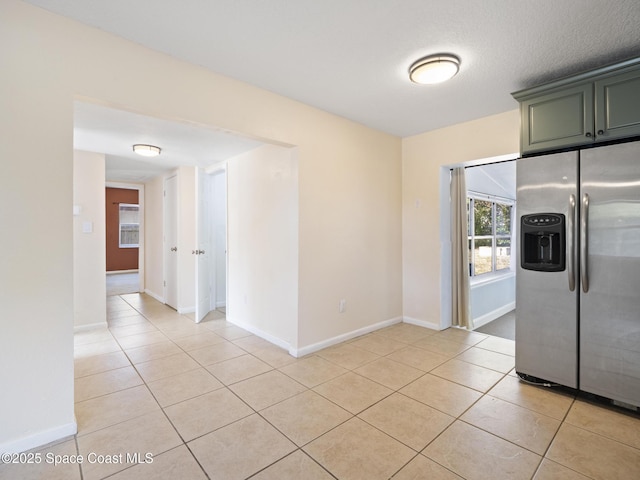 1640 Barna Ave, Titusville, FL 32780 - kitchen with baseboards, light tile patterned floors, and stainless steel fridge with ice dispenser
