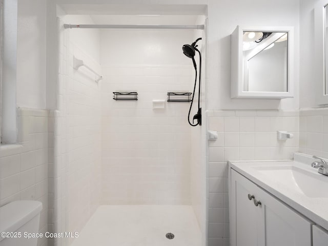 1640 Barna Ave, Titusville, FL 32780 - bathroom featuring a stall shower, wainscoting, vanity, tile walls, and toilet