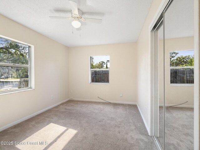1640 Barna Ave, Titusville, FL 32780 - unfurnished bedroom with baseboards, carpet floors, a ceiling fan, and a closet