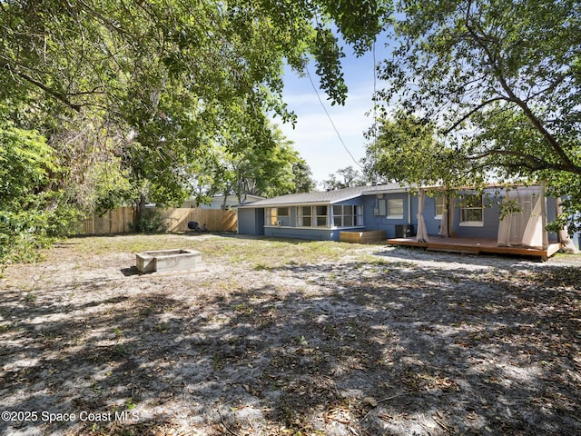 1640 Barna Ave, Titusville, FL 32780 - back of house featuring a fire pit, a wooden deck, and fence