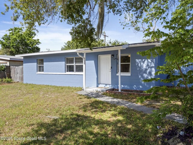 1640 Barna Ave, Titusville, FL 32780 - ranch-style house with concrete block siding, a front yard, and fence