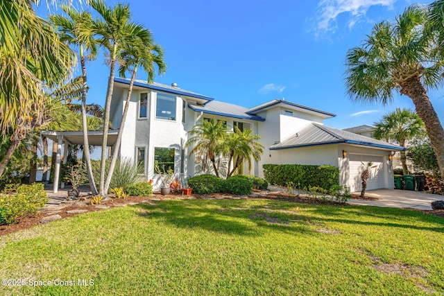 450 Ross Ave, Melbourne Beach, FL 32951 - view of front of property featuring a front yard, metal roof, a garage, stucco siding, and driveway