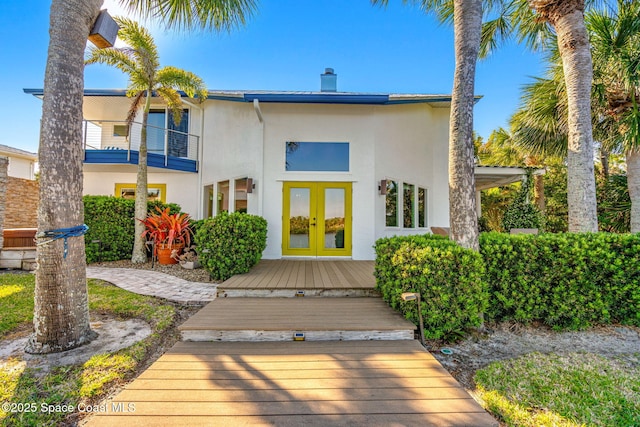 450 Ross Ave, Melbourne Beach, FL 32951 - rear view of house with french doors, a chimney, and stucco siding