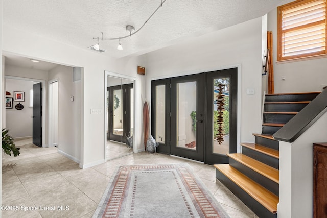 450 Ross Ave, Melbourne Beach, FL 32951 - foyer entrance with a textured ceiling, visible vents, stairs, tile patterned floors, and baseboards