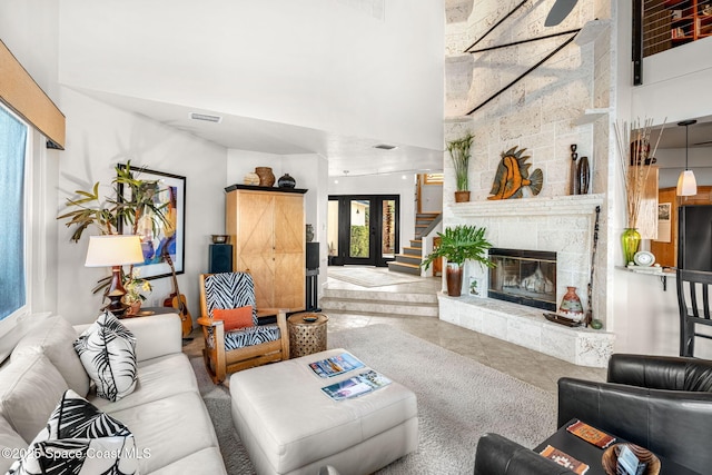 450 Ross Ave, Melbourne Beach, FL 32951 - living area featuring tile patterned floors, a towering ceiling, a stone fireplace, and a healthy amount of sunlight