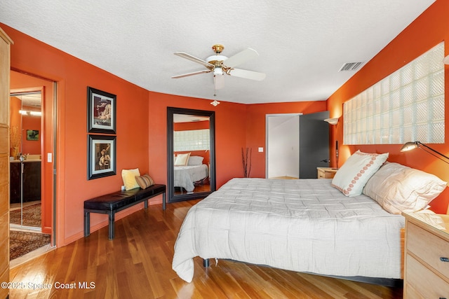 450 Ross Ave, Melbourne Beach, FL 32951 - bedroom with a textured ceiling, a ceiling fan, visible vents, wood finished floors, and baseboards