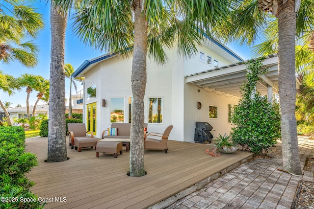 450 Ross Ave, Melbourne Beach, FL 32951 - back of property featuring an outdoor living space, a deck, and stucco siding