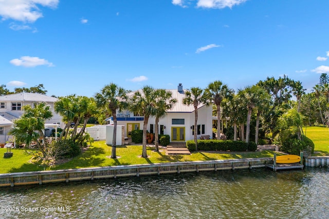 450 Ross Ave, Melbourne Beach, FL 32951 - rear view of house featuring french doors, a yard, and a water view