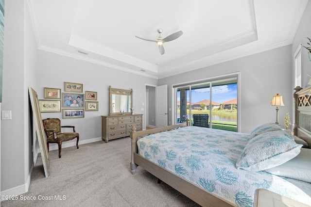 bedroom with carpet, a raised ceiling, access to exterior, visible vents, and crown molding