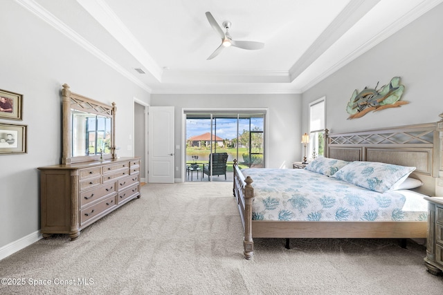 bedroom featuring a tray ceiling, access to outside, light colored carpet, and crown molding