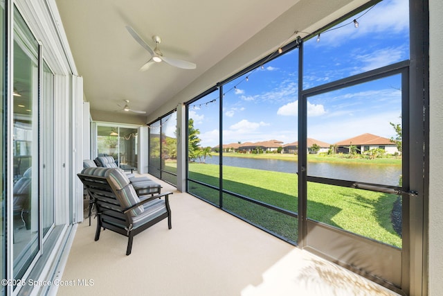 sunroom / solarium featuring a residential view, a water view, and a ceiling fan