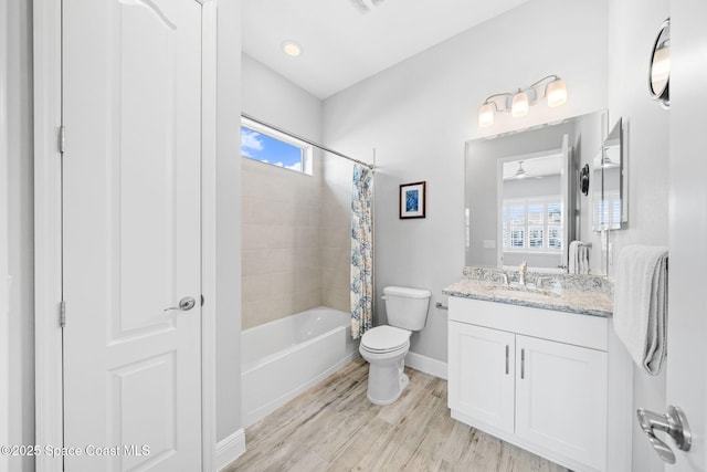 bathroom with wood finished floors, vanity, shower / bathtub combination with curtain, baseboards, and toilet