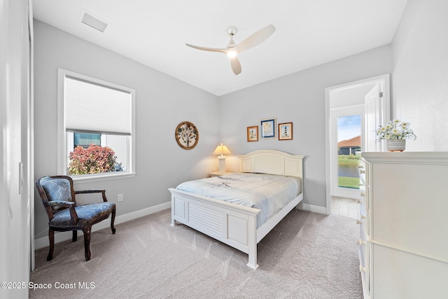 bedroom featuring light colored carpet, baseboards, and multiple windows