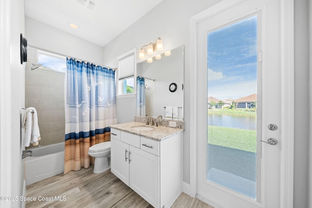 bathroom with shower / bath combination with curtain, wood finished floors, a water view, toilet, and vanity