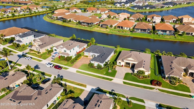 drone / aerial view featuring a water view and a residential view