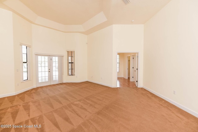 4068 Gardenwood Cir, Grant, FL 32949 - empty room with light colored carpet, a towering ceiling, french doors, and baseboards