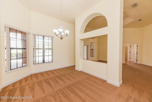 4068 Gardenwood Cir, Grant, FL 32949 - unfurnished room featuring light colored carpet, a high ceiling, a chandelier, and baseboards