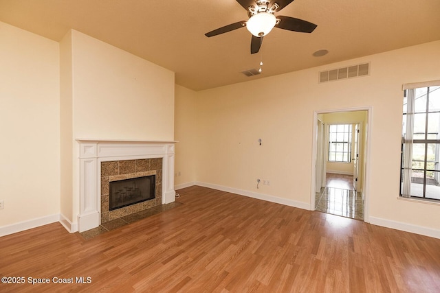 4068 Gardenwood Cir, Grant, FL 32949 - unfurnished living room with a ceiling fan, plenty of natural light, a fireplace, and wood finished floors