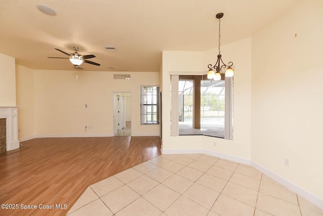 4068 Gardenwood Cir, Grant, FL 32949 - spare room with a chandelier, a ceiling fan, light wood-type flooring, and baseboards