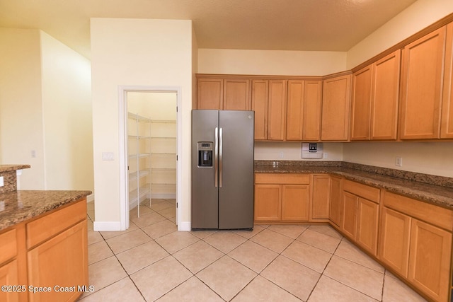 4068 Gardenwood Cir, Grant, FL 32949 - kitchen with stainless steel refrigerator with ice dispenser, light tile patterned floors, dark stone countertops, and baseboards