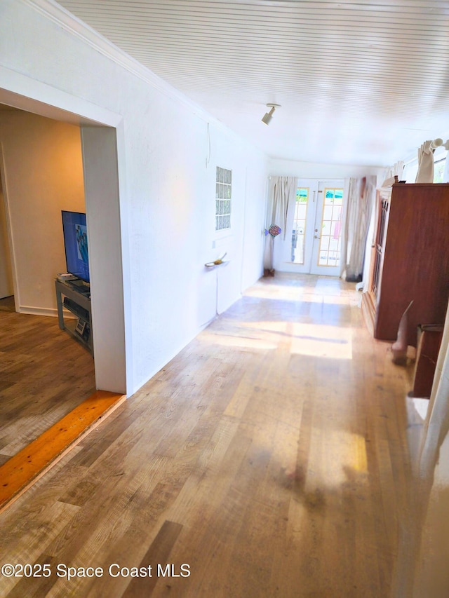 hall with wood finished floors, french doors, and crown molding