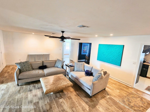 living room with light wood-type flooring, recessed lighting, baseboards, and ceiling fan