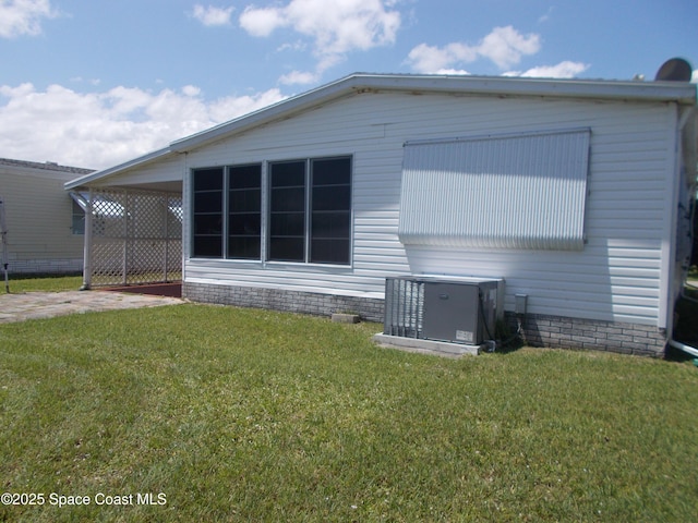 7637 Nianntic Ave Unit T5, Micco, FL 32976 - rear view of house featuring a yard, a carport, and central air condition unit